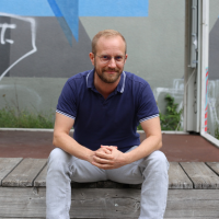 Bild von Sascha Rewald, sitzend auf einer Bank
